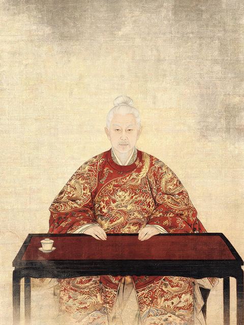 Ink painting on silk: a silver-haired minister in red and gold dragon robes sits very straight at an empty lacquered desk with one cup of tea.
